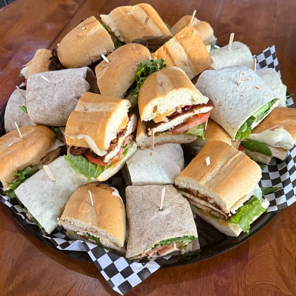 A platter of Stella Blue Bistro's breakfast sandwiches and wraps, cut in half and skewered.
